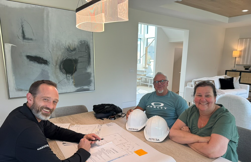 Kickoff meeting with construction manager reviewing custom home plans on site